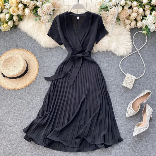 Mid-length pleated dress with high waist and V-neck in solid color